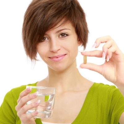 Woman holding Atrantil pill showing how to take Atrantil